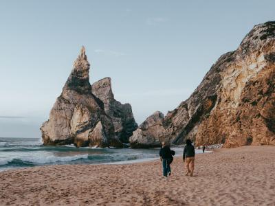 Explore the stunning Praia da Ursa in Portugal featuring unique rock formations and sandy beaches under a clear sky.