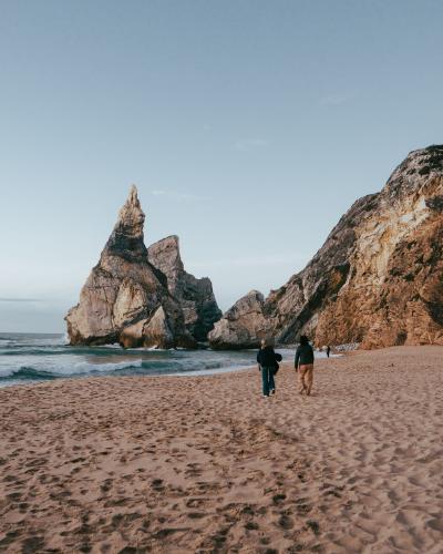 Explore the stunning Praia da Ursa in Portugal featuring unique rock formations and sandy beaches under a clear sky.