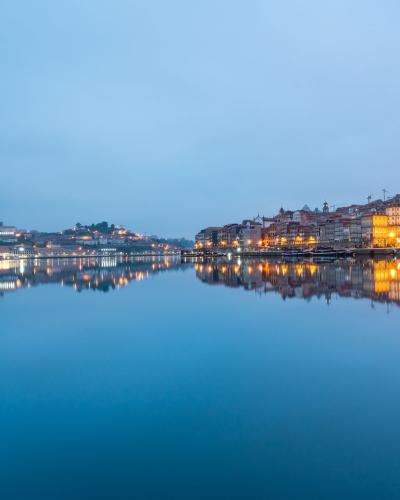 Stunning twilight reflection of Porto's cityscape on the Douro River.
