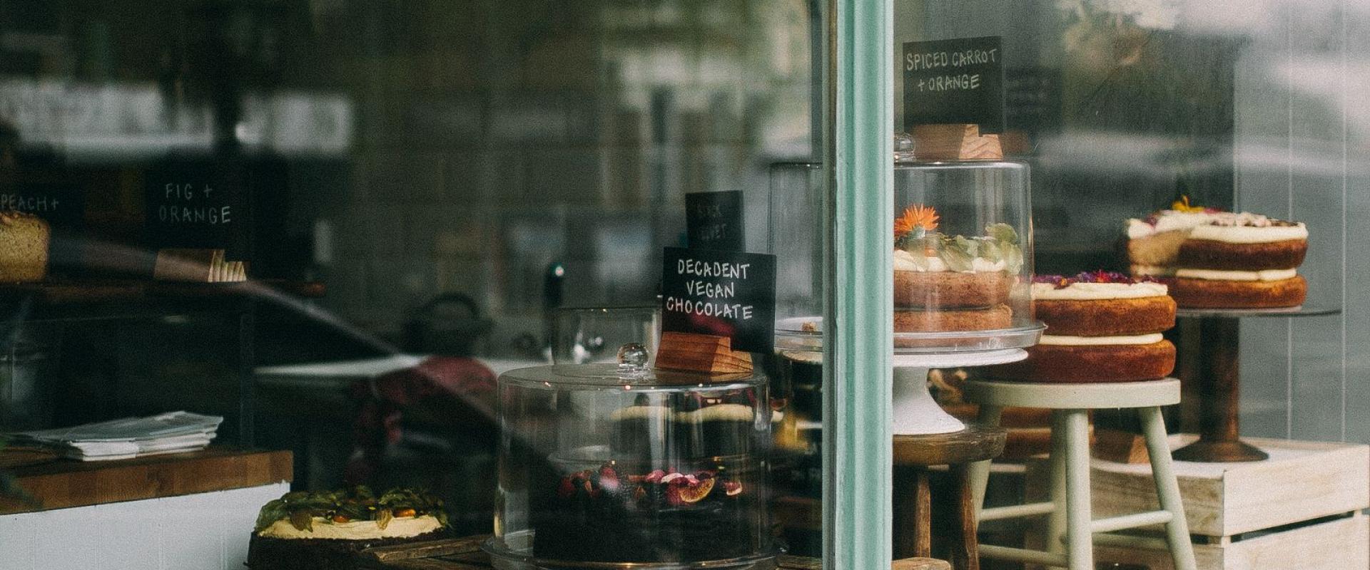 Warm and inviting cafe window display in Oxford showcasing fresh baked goods and cakes.