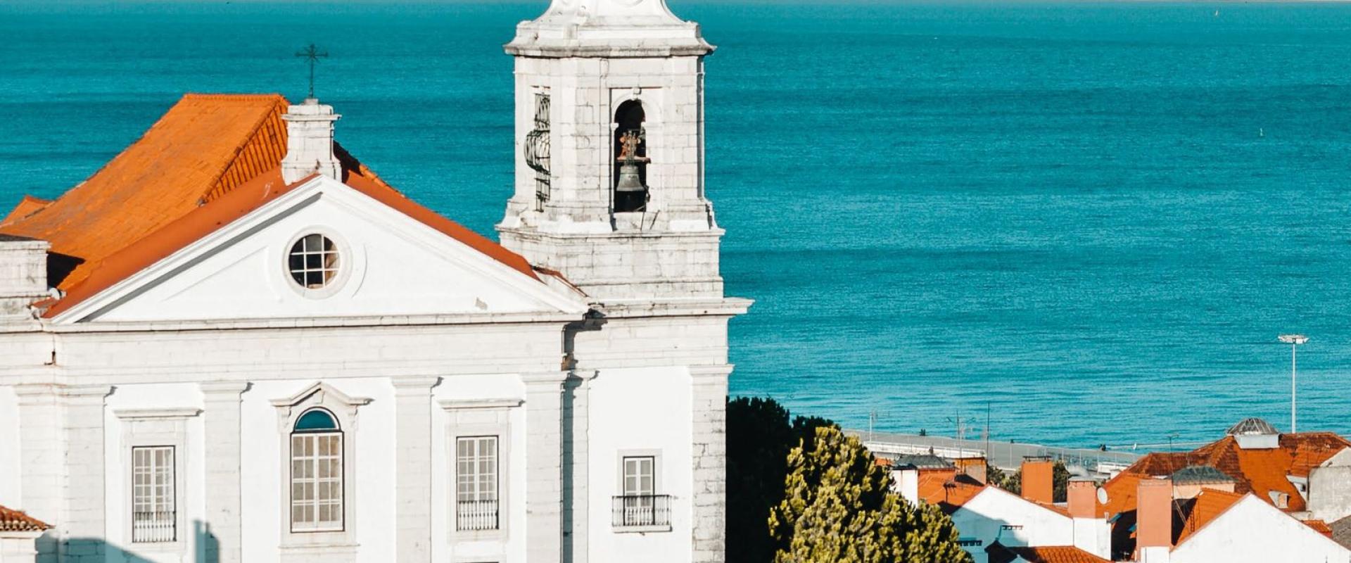 A picturesque view of Lisbon's Alfama district with traditional architecture overlooking the azure sea.