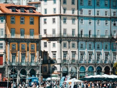 Colorful buildings of Porto's Ribeira district on a sunny day with tourists below.