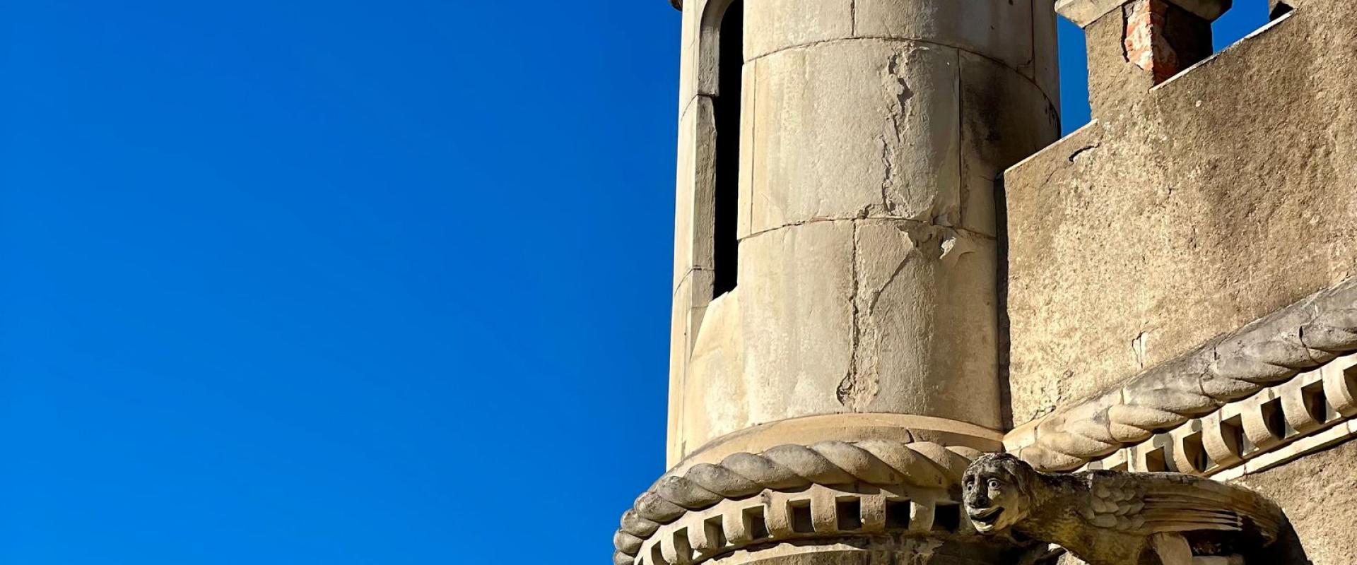 A detailed view of a historic stone turret against a clear blue sky in Luso, Portugal.