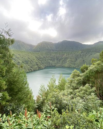 Deep crater lake ringed by steep green slopes in the Azores