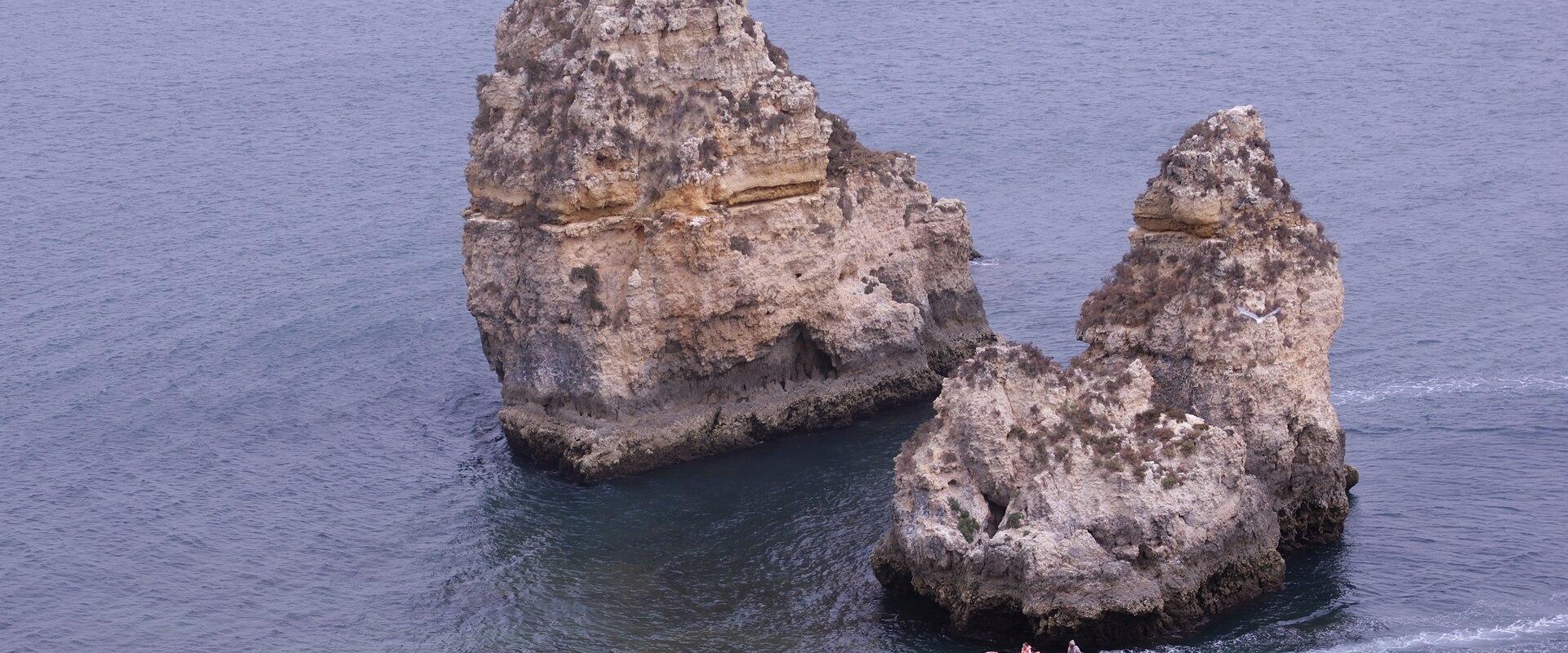 Sea stacks rising from calm water at Ponta da Piedade near Lagos on the Algarve coast