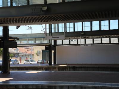 A view of a train station platform with overhead signage clearly reading "Aveiro" and "Aveiro" on the platform wall.