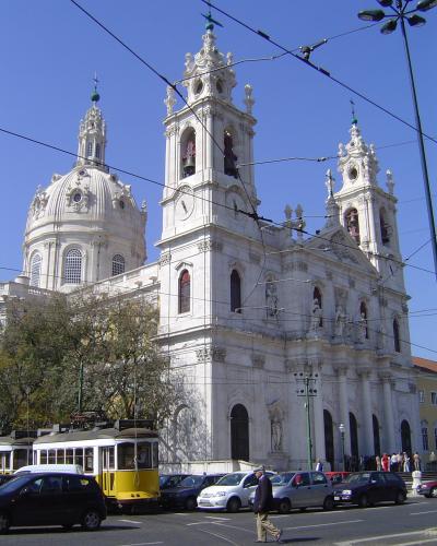 Facade and dome of Basilica da Estrela in Lisbon with a yellow tram passing