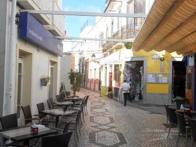 Café tables along a pedestrian street in Olhão