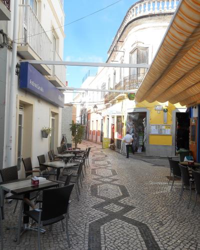 Café tables along a pedestrian street in Olhão