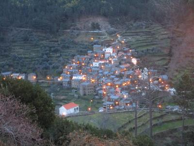 The schist village of Piódão lit up at dusk on a terraced hillside in the Beira mountains