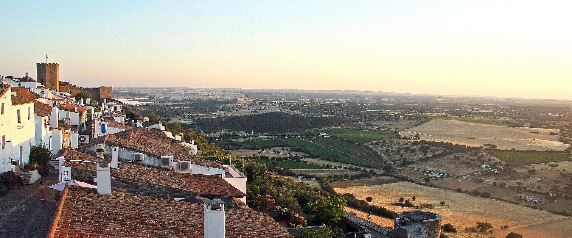 The whitewashed hilltop village of Monsaraz overlooking the Alentejo plains at sunset