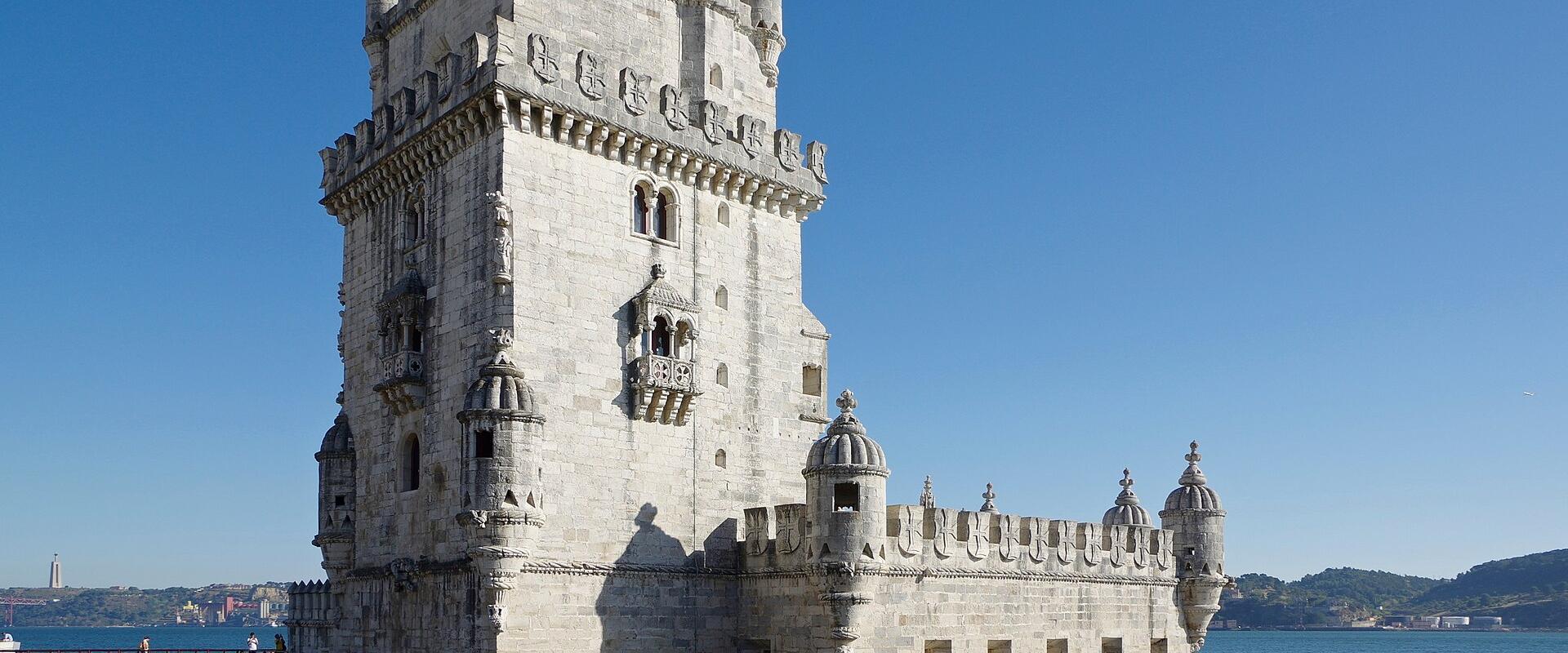 The Belém Tower on the Tagus riverbank in Lisbon under a clear blue sky