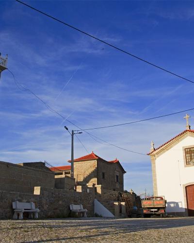 The whitewashed church and bell tower of Seixo do Côa under a blue sky