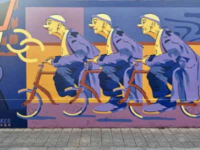 Colorful mural of cyclists by OKER, street art in Porto, Portugal
