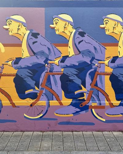 Colorful mural of cyclists by OKER, street art in Porto, Portugal
