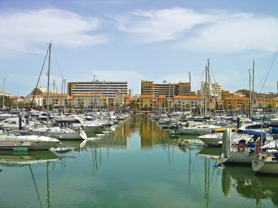 Yachts and sailboats moored in Vilamoura Marina with waterfront buildings behind