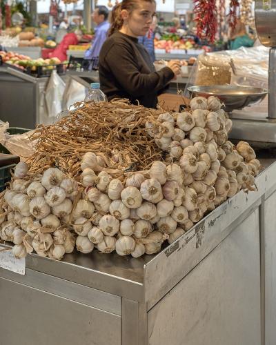 Produce stall piled with garlic inside Mercado do Bolhao, Porto