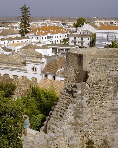 The walls of Tavira castle above the whitewashed rooftops of the town