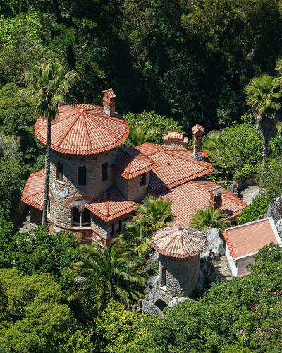 Aerial view of Vila Sassetti and its circular tower amid the wooded hills of Sintra