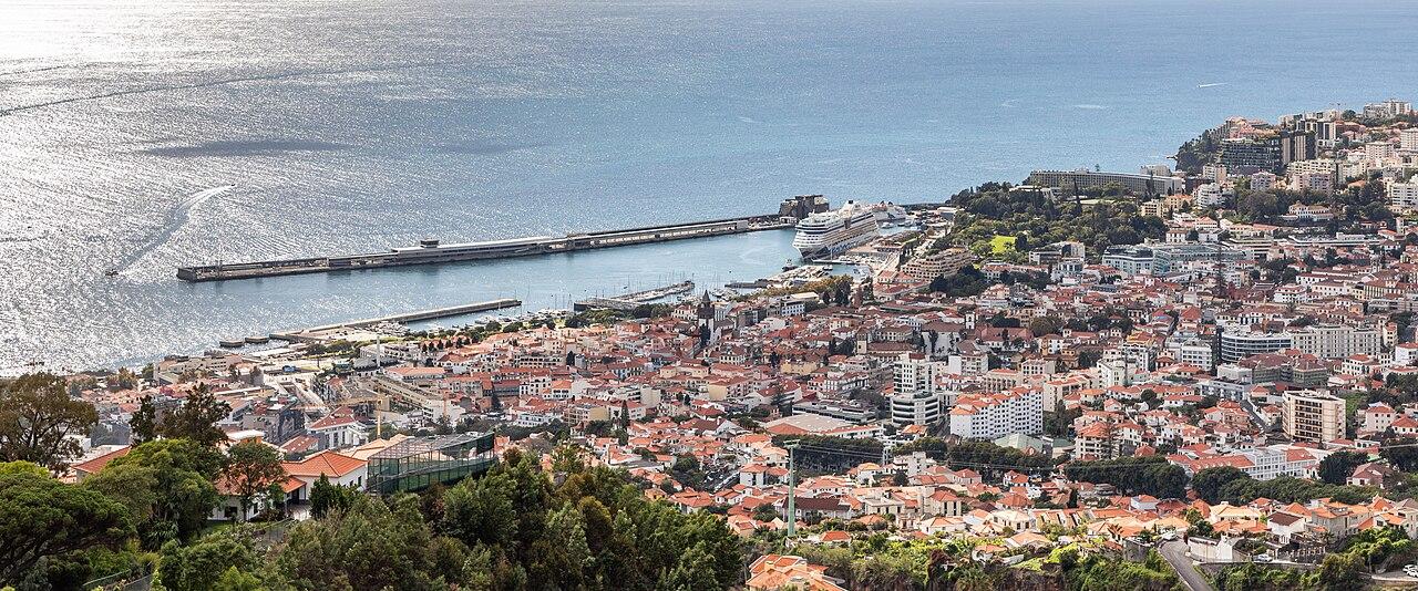 Funchal's red roofs and harbour stretching along the bay below green hillsides