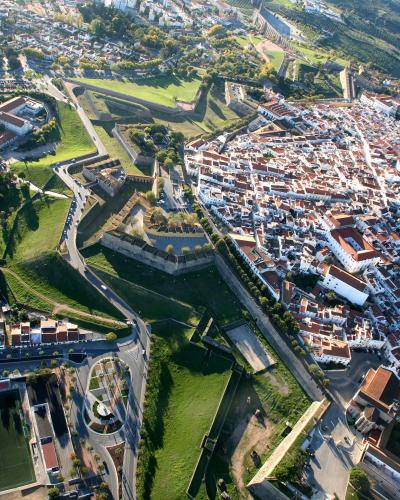 An aerial photograph showing the extensive star-shaped fortifications, green glacis, and dense urban area of a historic fortified city.