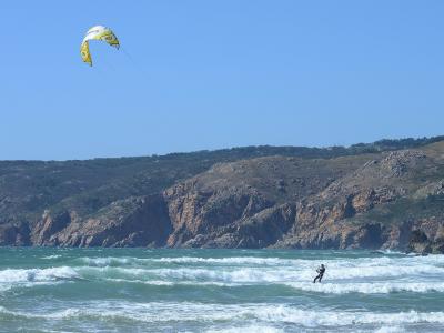 Atlantic surf and kitesurfers at Praia do Guincho below the Sintra hills