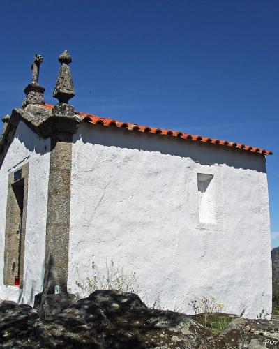 A whitewashed chapel of the São Salvador do Mundo sanctuary among trees above the Douro
