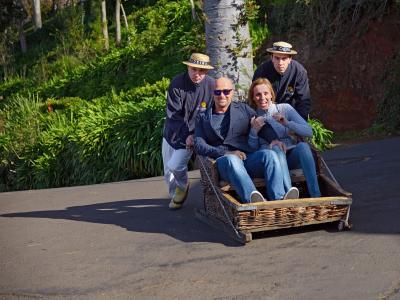 Carreiros pushing a traditional wicker toboggan downhill at Monte, Funchal, Madeira