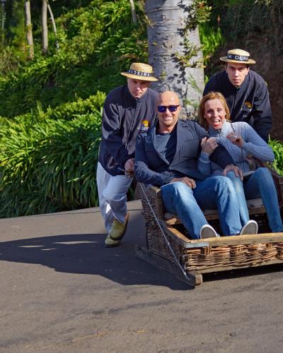 Carreiros pushing a traditional wicker toboggan downhill at Monte, Funchal, Madeira