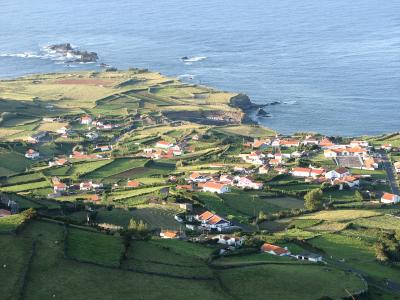 Coastal village of Ponta Delgada amid green fields on Flores Island, Azores