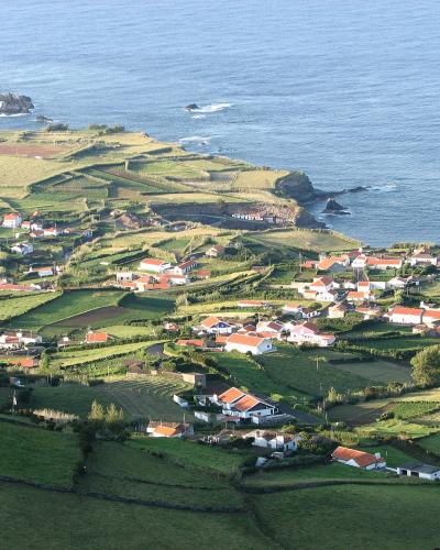 Coastal village of Ponta Delgada amid green fields on Flores Island, Azores
